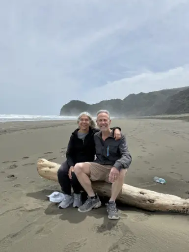Couple walking on West Auckland NZ beach
