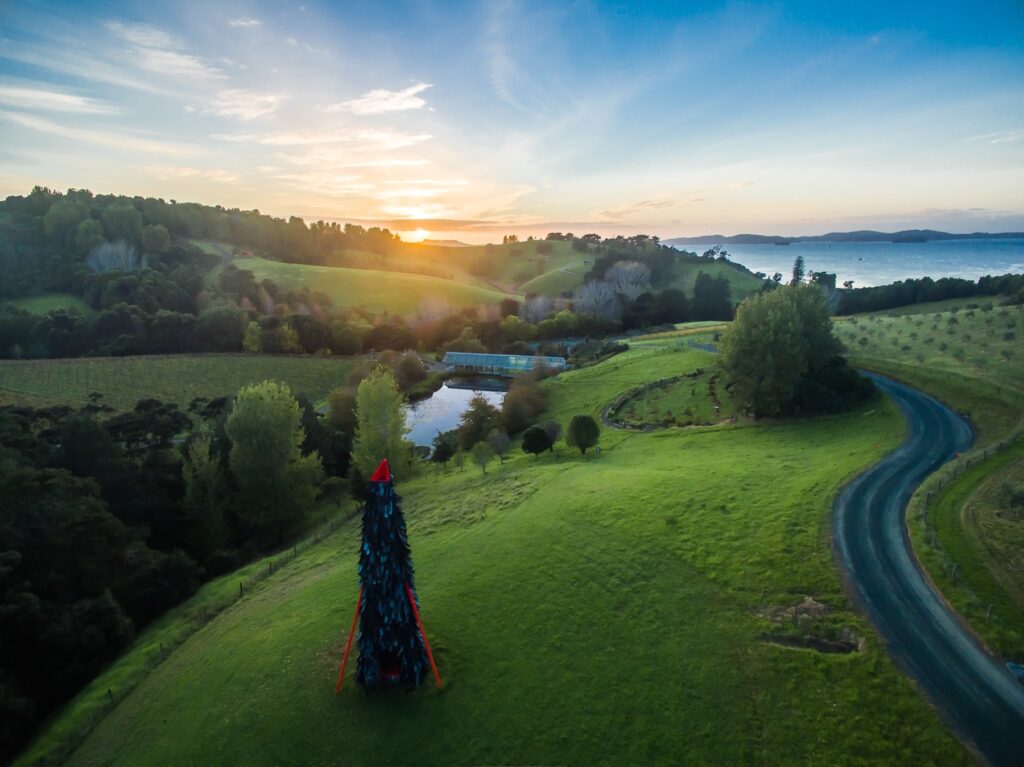 A sculpture overlooking the Brick Bay vineyard and the Matakana Coast at sunset