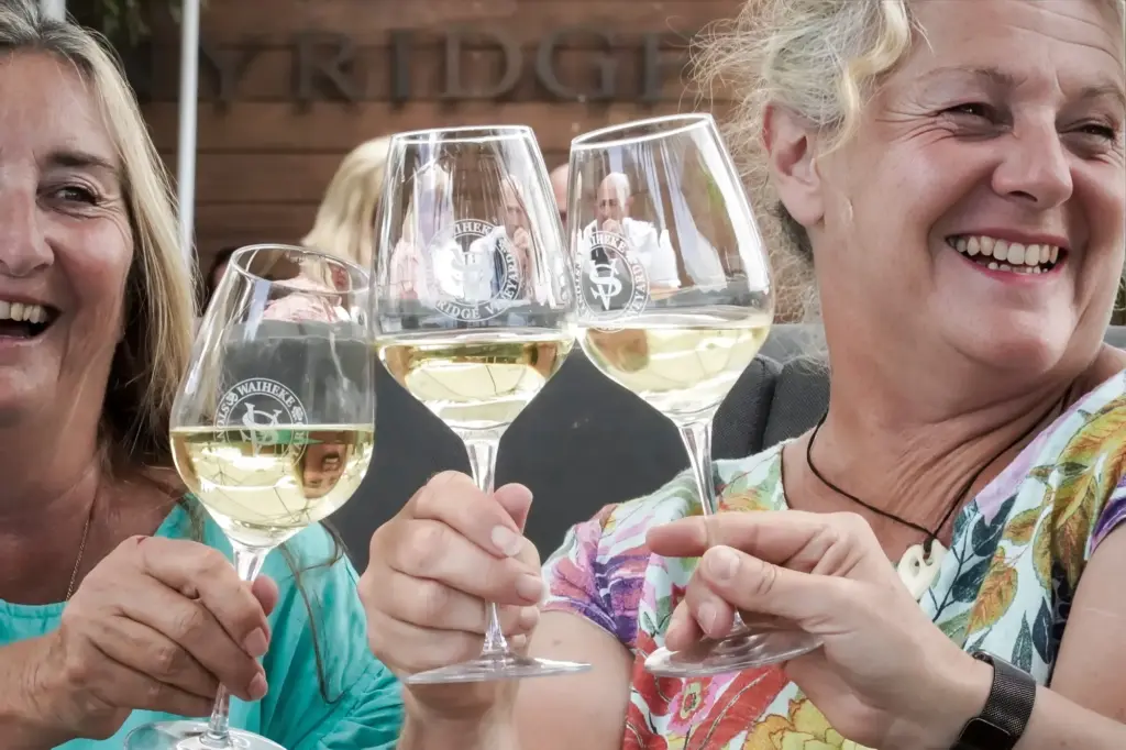 Guests laughing over a wine tasting at Stonyridge vineyard, Waiheke Island