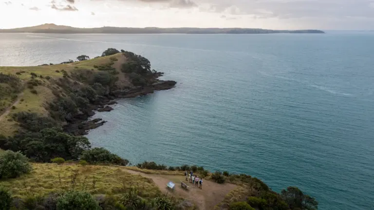 Small group walking the Matiatia headland on the Double Headland Walk, Waiheke Island