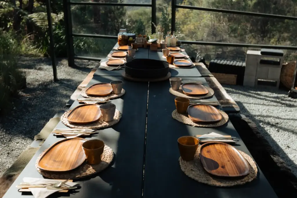 A long table set with wooden plates in the Velskov forest pavilion
