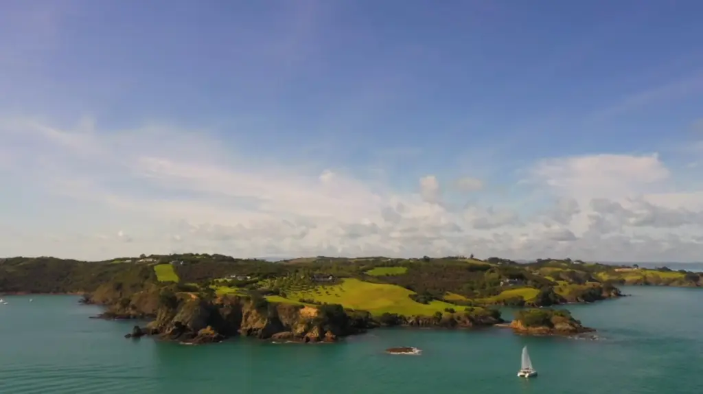 Waiheke Island headland and a yacht in the Hauraki Gulf