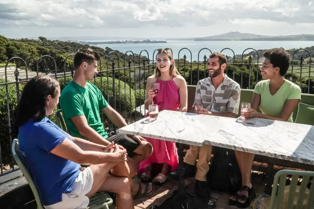 Guests enjoying a wine tasting with Hauraki Gulf views at Mudbrick, Waiheke Island